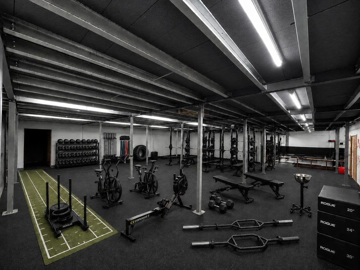 The strength gym: racks, bikes, a rower, a sled track and kettlebells